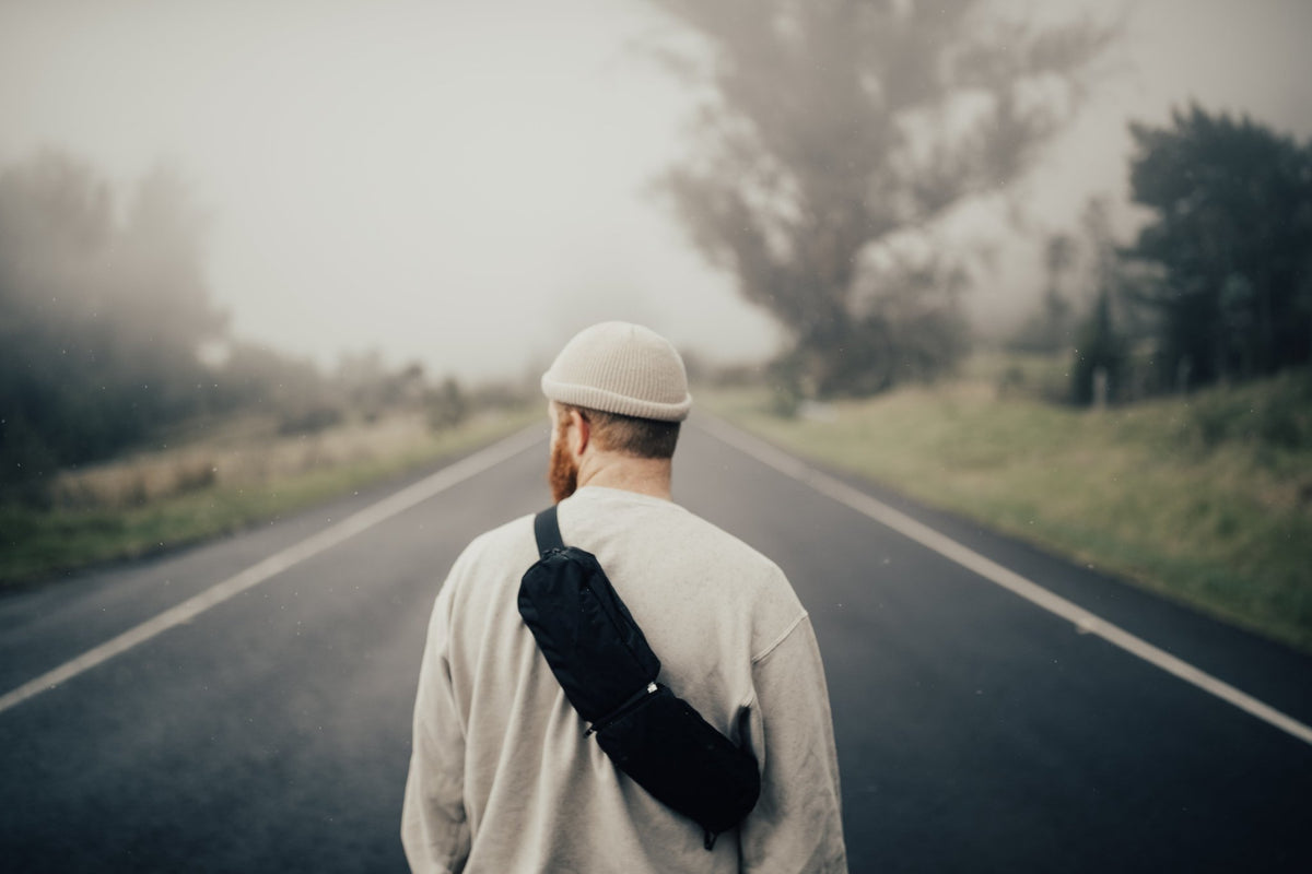 2L Sling Belt (42L Backpack Waist Belt/Sling Bag) - Gravel - Man wearing 2 Liter sling bag across back walking down the street
